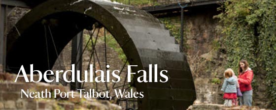 Visitors at the waterwheel and site of the former tin-works at Aberdulais Falls, Neath Port Talbot, Wales
