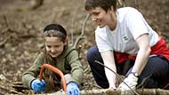 Families learning about woodland skills on a working holiday at Clumber Park, Nottinghamshire